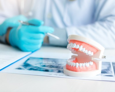 doctor showing dentures to patient