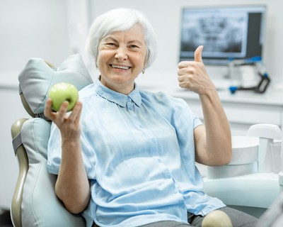 doctor showing dentures to patient